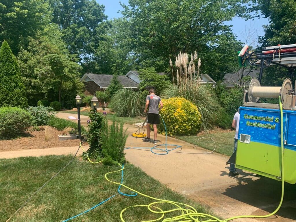 Paul Brothers SoftWash technician professionally cleaning concrete