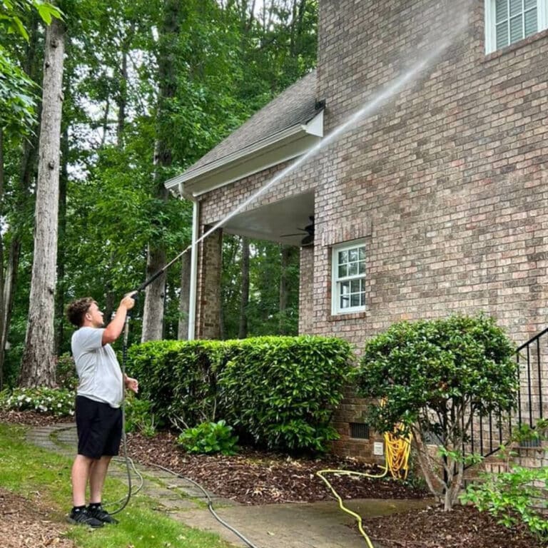professional contractor delivering pressure washing service to outdoor house wall in trinity north carolina