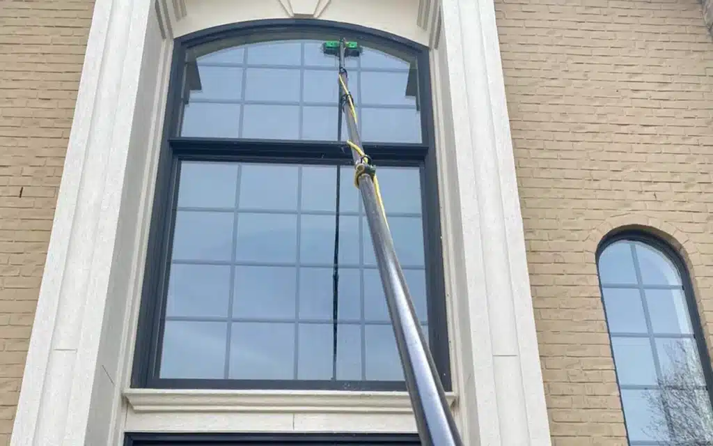 Paul Brothers SoftWash cleaning exterior windows with a pure-water pole