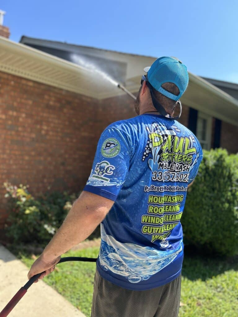 Paul Brothers team member in work shirt pressure washing greensboro nc home