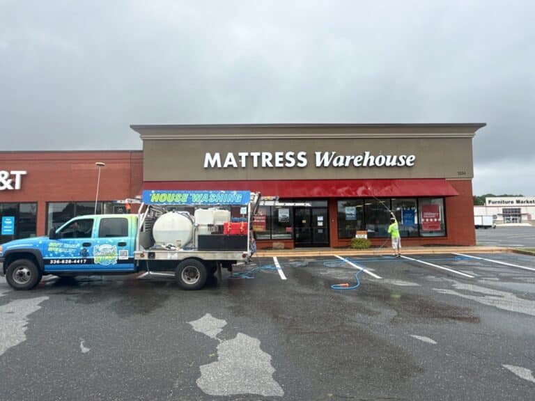 Professional storefront awning cleaning service removing algae and dirt from a commercial building awning in Asheboro NC