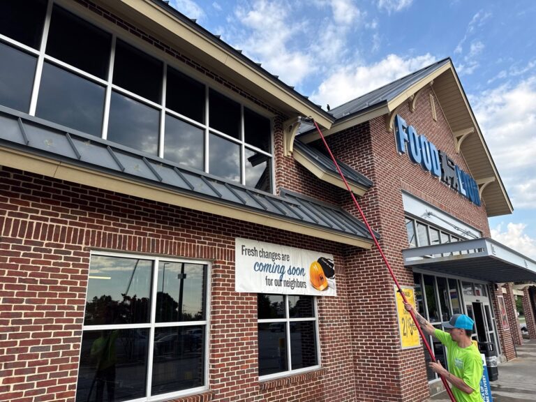 Technician cleaning exterior windows with a water-fed pole system